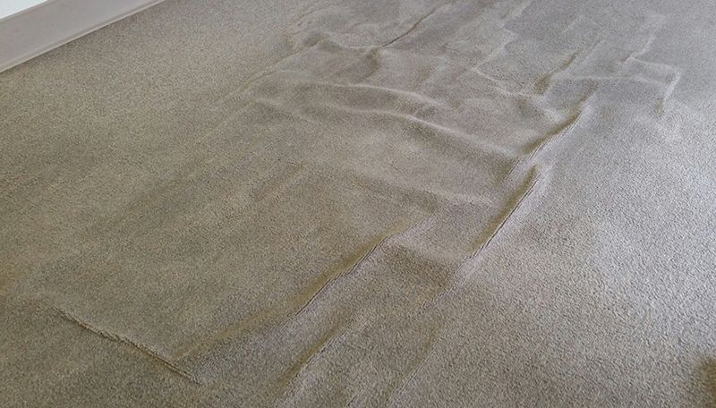 What causes carpets to buckle